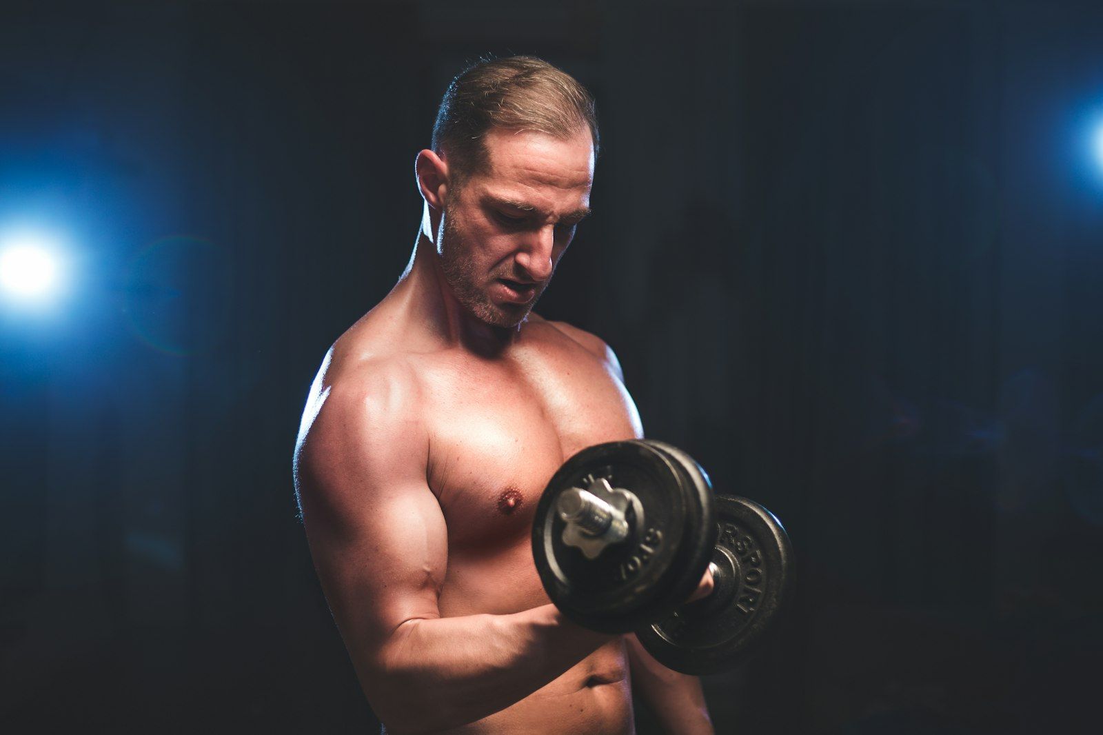 A fit man curling a pair of dumbbells